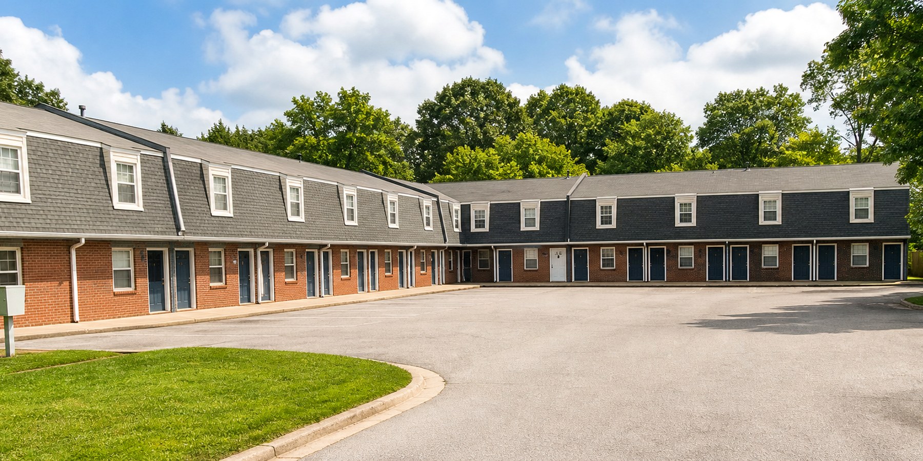 Red Oak Apartments courtyard exterior with brick buildings, trees, lawn, and clean parking area